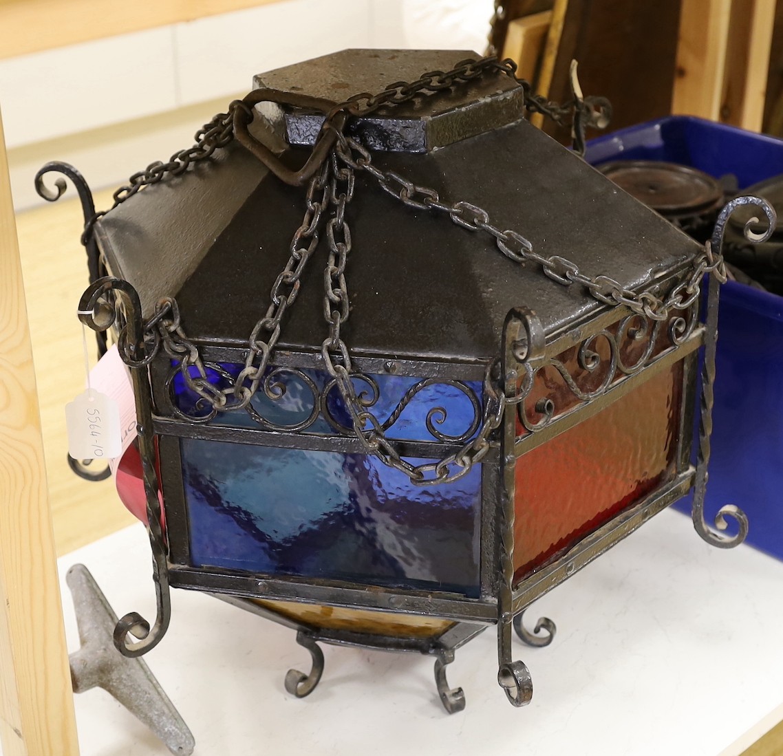 A large Victorian style hexagonal wrought iron hanging lantern with stained glass